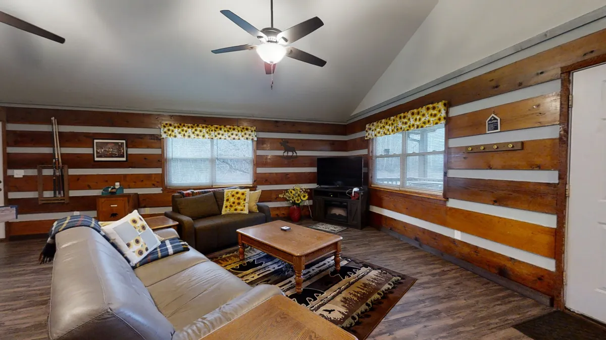 A cozy living room with a comfortable sofa, coffee table, flat-screen television, and decorative windows. The setup encourages relaxation and entertainment, perfect for movie nights or storytelling sessions.